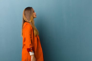 Profil görünümünde genç ve güzel bir kadın ilerideki boşluğu kopyalamaya çalışıyor, düşünüyor, hayal ediyor ya da hayal kuruyor.