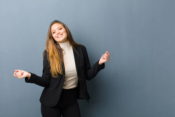 businesswoman smiling, feeling carefree, relaxed and happy, dancing and listening to music, having fun at a party