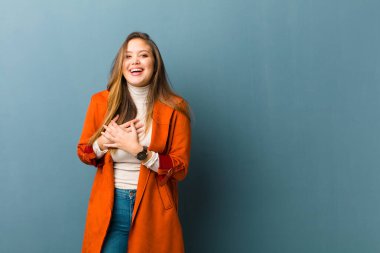 Genç, güzel bir kadın romantik, mutlu ve aşık, neşeyle gülümseyen ve kalbe yakın el ele tutuşan
