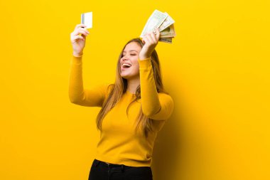 Genç, güzel bir kadın parası ya da sarı duvara karşı alışveriş konsepti