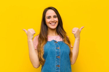 Genç ve güzel bir kadın neşeyle gülümsüyor ve mutlu görünüyor, kaygısız ve pozitif hissediyor.