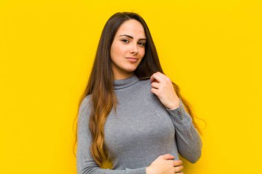 Genç, güzel bir kadın kibirli, başarılı, pozitif ve gururlu görünüyor. Kendini işine ya da iş konseptine işaret ediyor.