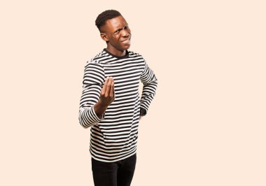 Genç Afrikalı Amerikalı siyahi adam kapiş ya da para hareketi yapıyor, sana borçlarını ödemeni söylüyor! Bej duvara yaslan