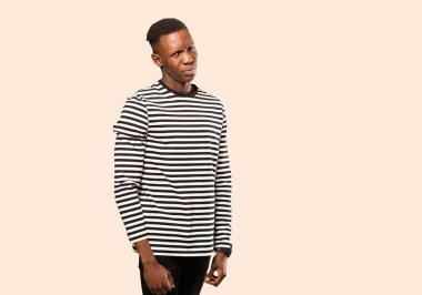 Genç Afrikalı Amerikalı siyah adam gururlu, kendinden emin, havalı, küstah, küstah, gülümseyen, bej rengi duvara karşı kendini başarılı hisseden