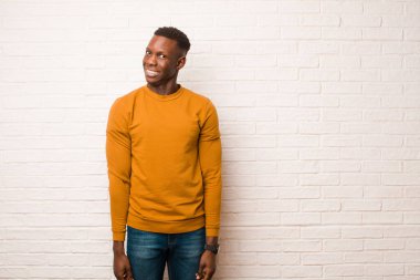 Genç Afrikalı Amerikalı siyah adam endişeli, stresli, endişeli ve korkmuş görünüyor, panikliyor ve tuğla duvara karşı dişlerini sıkıyor.