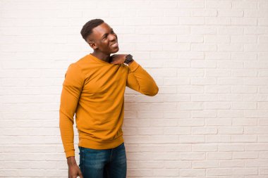 Genç Afro-Amerikan siyahi adam stresli, endişeli, yorgun ve hayal kırıklığına uğramış, gömlek yakalı, tuğla duvara karşı sorunlu görünüyor