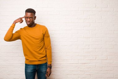 Genç Afrikalı Amerikalı siyahi adam şaşkın ve şaşkın hissediyor. Deli, deli ya da aklını kaçırmış olduğunu gösteriyor.