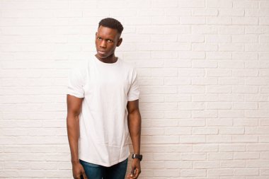 Genç Afrikalı Amerikalı siyahi adam üzgün, üzgün ya da kızgın hissediyordu. Olumsuz bir tavır sergiliyordu. Tuğla duvara karşı anlaşmazlık içindeydi.