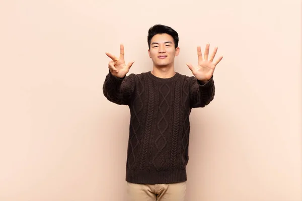 Ung Kinesisk Man Ler Och Ser Vänlig Visar Nummer Åtta — Stockfoto