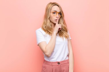 Genç, güzel, sarışın bir kadın sessizlik ve sessizlik istiyor. Parmağını ağzının önüne uzatıp 