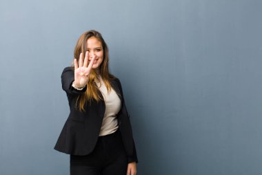İş kadını gülümsüyor ve arkadaş canlısı görünüyor. Elleri önde, geriye doğru sayıyor.