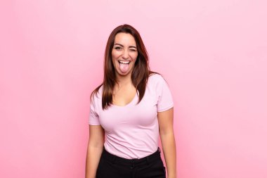 Neşeli, kaygısız, asi tavrıyla genç, güzel bir kadın. Şakalar yapıyor, dillerini dışarı çıkarıyor, pembe duvarlara karşı eğleniyor.