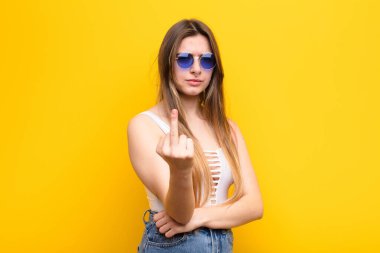 Genç ve güzel bir kadın kızgın, sinirli, isyankar ve agresif hissediyor, orta parmağını sallıyor, karşı koyuyor.