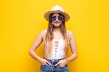 Genç ve güzel bir kadın neşeli ve tesadüfen gülümsüyor. Olumlu, mutlu, kendinden emin ve rahat bir ifadeyle.