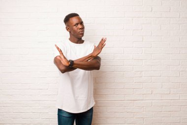 Genç Afro-Amerikan siyahi adam tavrından rahatsız ve sıkılmış görünüyor. Yeter artık! Eller önde, tuğla duvara karşı durmanı söylüyor.