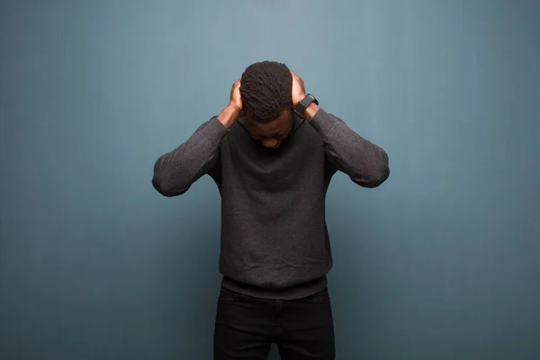 若いアフリカ系アメリカ人黒人男性はストレスと不満を感じ頭に手を挙げ疲れを感じ不満を感じ片頭痛を感じグランジウォールに対して — ストック写真