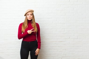 Genç sanatçı kadın kendini mutlu, pozitif ve başarılı hissediyor, göğsünde el yapımı V ile, zafer ya da barış gösteriyor.