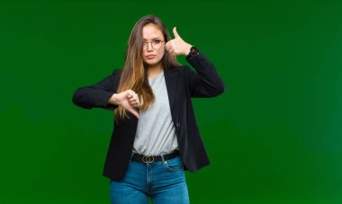 Genç ve güzel bir kadın kafası karışık, bilgisiz ve kararsız hissediyor, iyi ve kötü seçenekleri ya da yeşil arka planla karşılaştırarak tartıyor.