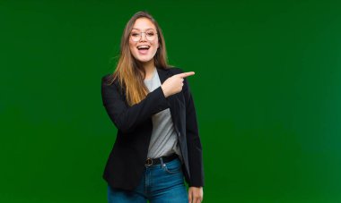 Genç, güzel bir kadın kendini cahil ve şaşkın hissediyor, hiçbir fikri yok, yeşil arka plana karşı aptal ya da aptal bir bakışla tamamen kafası karışmış.