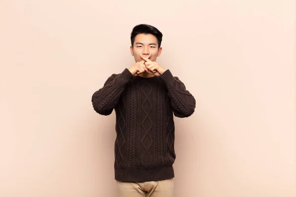 Jovem Chinês Olhando Sério Descontente Com Ambos Dedos Cruzados Frente — Fotografia de Stock