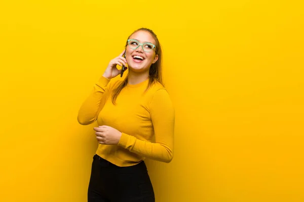 Sarı Arka Planda Akıllı Telefonu Olan Genç Güzel Bir Kadın — Stok fotoğraf