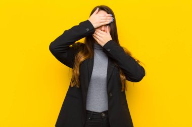 Genç ve güzel bir kadın iki eliyle kameraya hayır diyerek yüzünü kapatıyor! Resimleri reddetmek ya da fotoğraf işini ya da iş konseptini yasaklamak