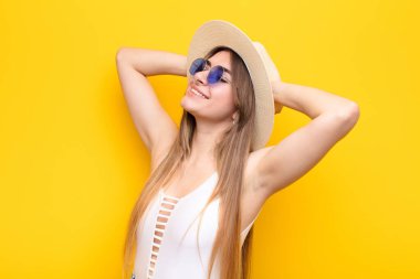 Genç ve güzel bir kadın gülümsüyor ve rahatlıyor, tatmin oluyor ve kaygısız, neşeli ve rahatlatıcı.