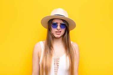 Genç, güzel bir kadın şaşkın ve şaşkın hissediyor, aptal, sersemlemiş bir ifadeyle beklenmedik bir şeye bakıyor.