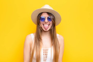 Genç ve güzel bir kadın, tiksinmiş ve rahatsız olmuş hissediyor. Dilini dışarı çıkarıyor, iğrenç ve iğrenç bir şeyden hoşlanmıyor.