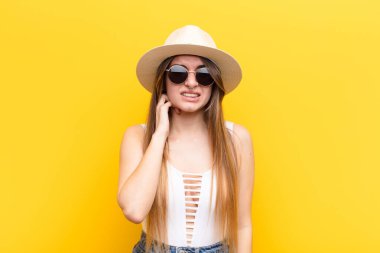 Genç ve güzel bir kadın stresli, hayal kırıklığına uğramış ve yorgun, endişeli ve sorunlu bir bakışla boynunu ovalıyor.