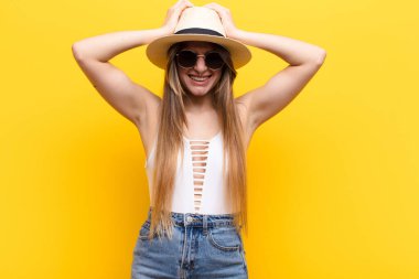 Genç ve güzel bir kadın stresli ve hayal kırıklığına uğramış hissediyor, elele tutuşuyor, yorgun, mutsuz ve migren ağrısı çekiyor.