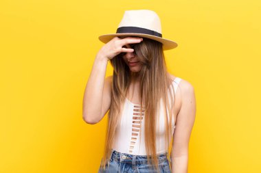 Genç ve güzel bir kadın stresli, mutsuz ve hayal kırıklığına uğramış, alnına dokunuyor ve şiddetli baş ağrısı çekiyor.