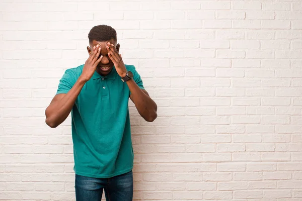 若いアフリカ系アメリカ人黒人男性はストレスと不満を感じ 頭痛の種で圧迫され レンガの壁に対する問題に悩まされていました — ストック写真