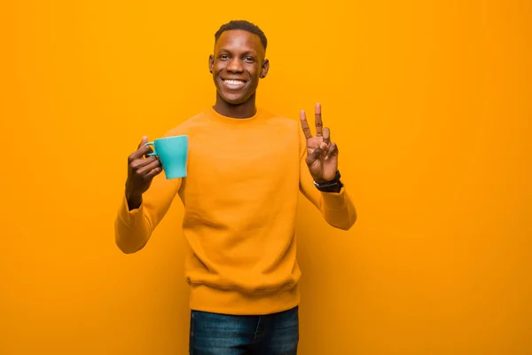 Молодой Афроамериканец Черный Мужчина Против Оранжевой Стены Чашкой Кофе — стоковое фото