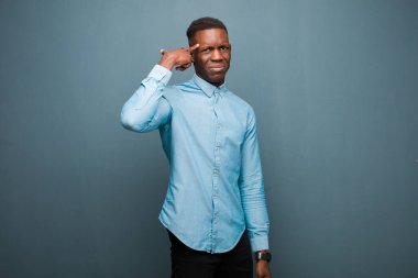 Genç Afrikalı Amerikalı siyahi adam şaşkın ve şaşkın hissediyor. Deli, deli ya da aklını kaçırmış olduğunu gösteriyor.