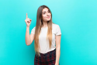 Genç ve güzel bir kadın, mavi duvara karşı 