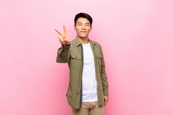 Jovem Chinês Homem Sorrindo Olhando Feliz Despreocupado Positivo Gesticulando Vitória — Fotografia de Stock