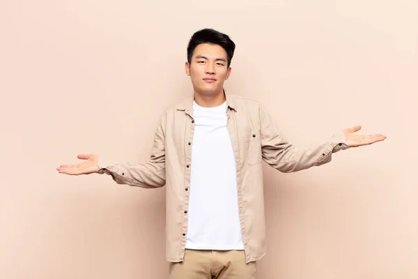 Ung Kinesisk Man Ser Förbryllad Förvirrad Och Stressad Undrar Mellan — Stockfoto