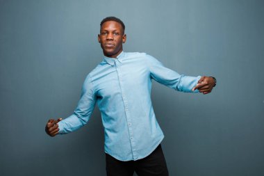 Genç Afrikalı Amerikalı siyah adam gururlu, kibirli, mutlu, şaşırmış ve tatmin olmuş görünüyor.