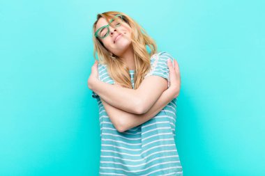 Genç, güzel, sarışın bir kadın aşık, gülümseyen, sarılan ve kendine sarılan, bekar kalan, bencil ve benmerkezci biri.