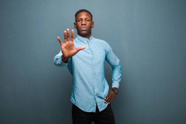 Genç Afro-Amerikan siyahi adam ciddi, sert, hoşnutsuz ve kızgın görünüyor.