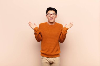 Genç Çinli adam mutlu ve heyecanlı görünüyordu. Beklenmedik bir sürprizle şoke olmuştu. İki eli de düz duvarın yanında duruyordu.