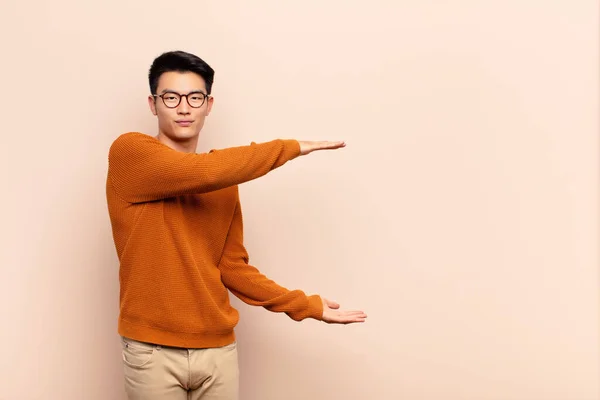 Jovem Chinês Homem Segurando Objeto Com Ambas Mãos Espaço Cópia — Fotografia de Stock