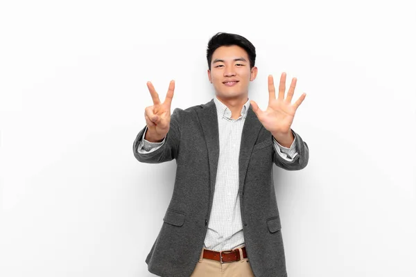 Jovem Chinês Homem Sorrindo Olhando Amigável Mostrando Número Sete Sétimo — Fotografia de Stock