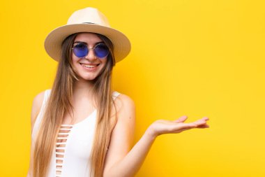 Genç, güzel bir kadın kendini mutlu hissediyor ve gülümsüyor. Yan taraftaki bir nesneye ya da konsepte bakıyor.