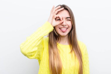 Genç ve güzel bir kadın mutlu bir şekilde gülümsüyor, şaka yapıyor ve gözetleme deliğinden bakıyor, sırları gözetliyor.