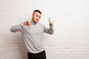 Genç yakışıklı, kafası karışmış, bilgisiz ve kararsız hissediyor, iyi ve kötü seçenekleri ya da düz arkaplan seçeneklerini tartıyor.