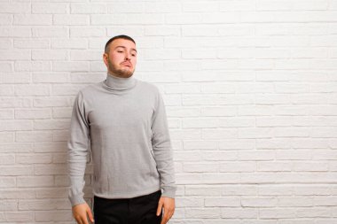 Aptal bakışlı, aptal ve komik görünen genç bir adam. Şaşı bakışlı, şakacı ve düz duvara karşı oynaşan.