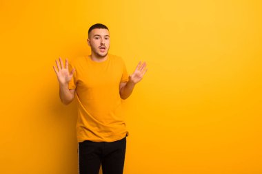 Genç yakışıklı adam gergin, endişeli ve endişeli görünüyor, benim hatam olmadığını söylüyor, yoksa düz arkaplana karşı yapmazdım. 