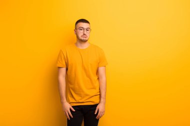 Genç, yakışıklı bir adam üzgün ve stresli. Kötü bir sürpriz yüzünden üzgün. Düz zemine karşı olumsuz ve endişeli bir bakış.